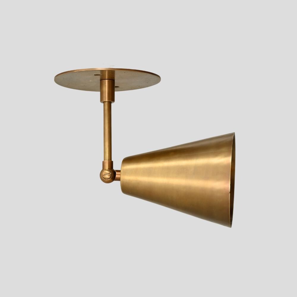 Adjustable brass arm wall sconce with a raw brass finish handmade by LightCove