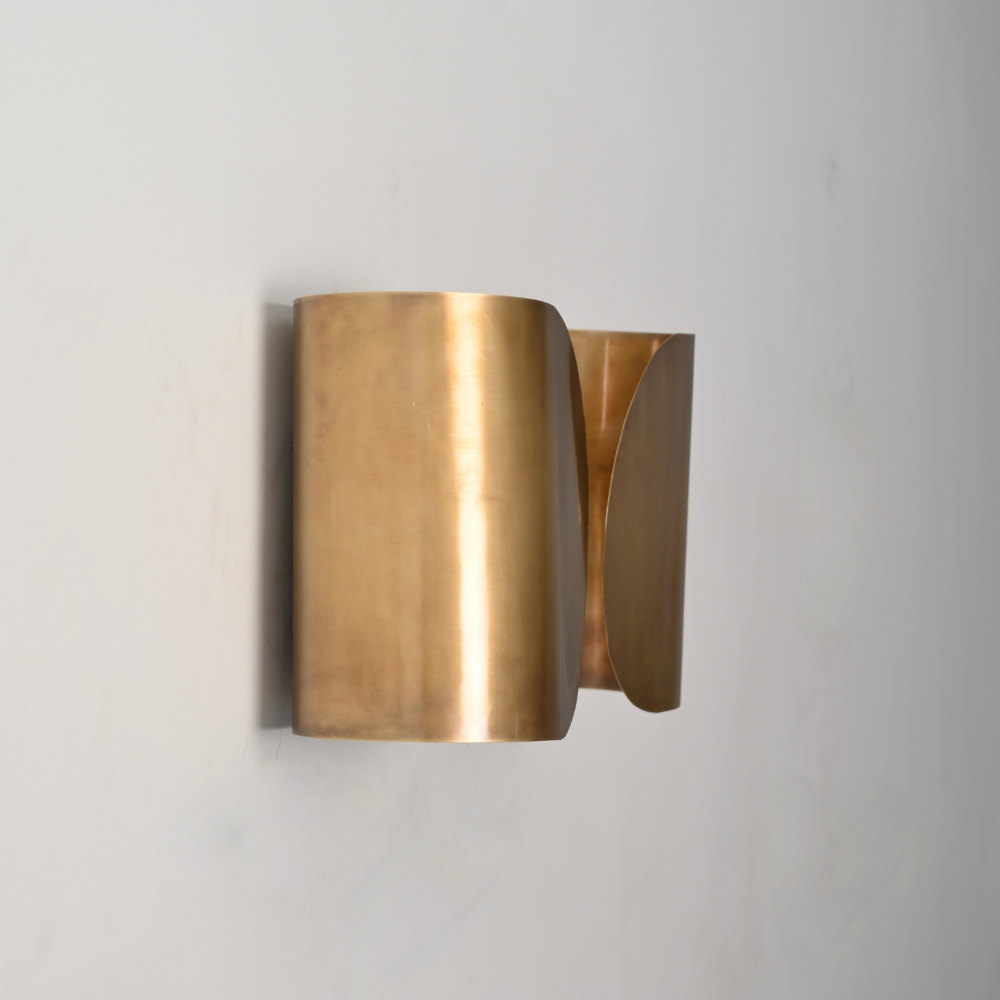 modern brass butterfly fly sconce with a double curved shade on a gray wall