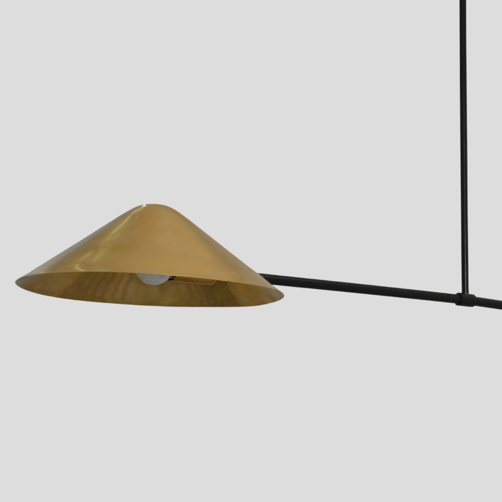 Close up on the cone raw brass shade of a modern handmade ceiling light
