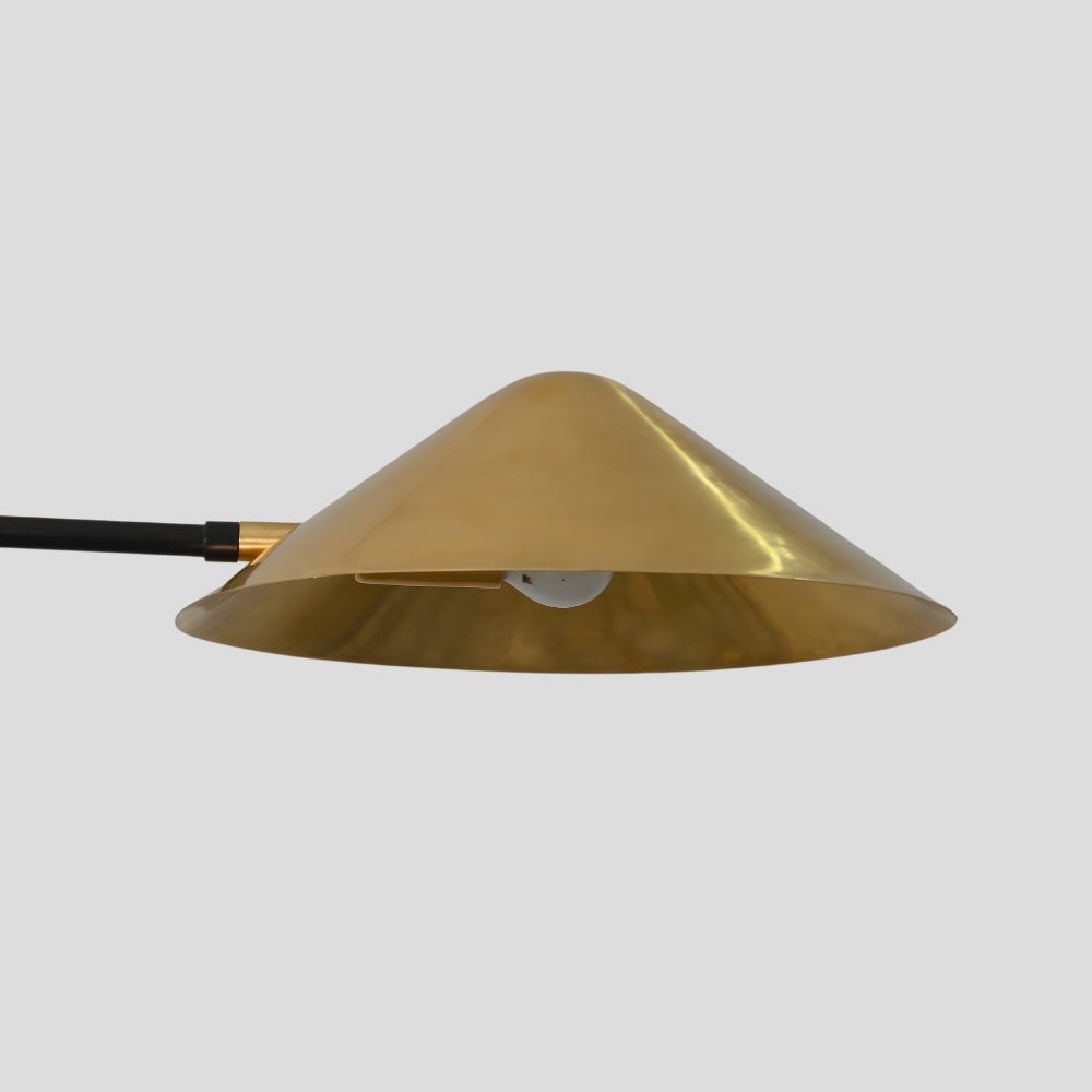 Close up on a handcrafted cone brass shade on a gray background