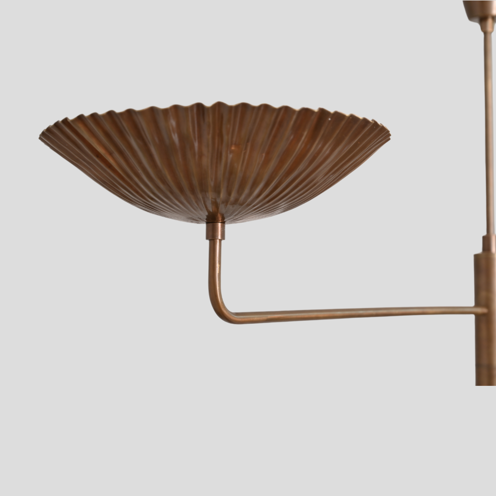 Brass wall-mounted lamp with ribbed design on a light gray background