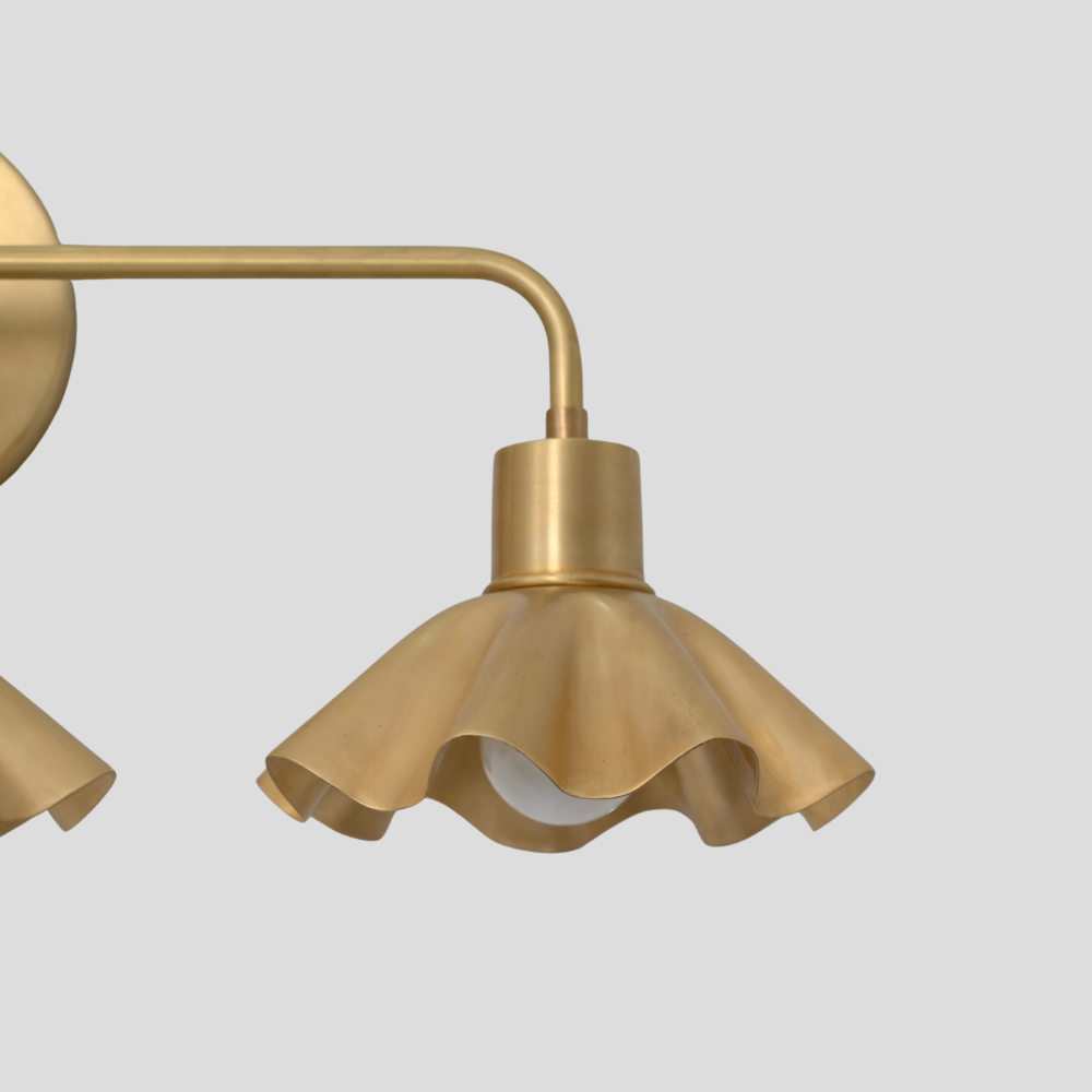 Close up on the raw brass finish of the petal shade of a vanity light