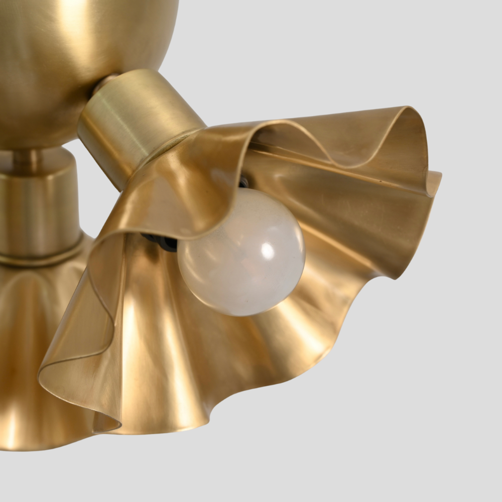 Close up on the raw brass finish of the flower shaped shade an handmade ceiling light