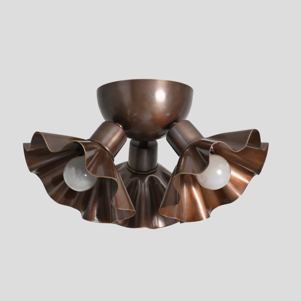 Bronze ceiling light fixture with three lampshades on a gray background