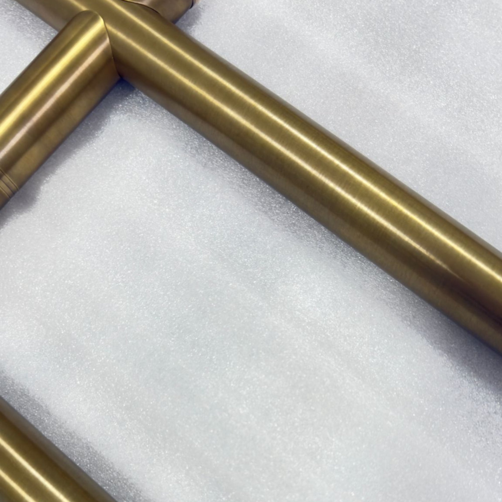 Gold metal pipe on a white foam background