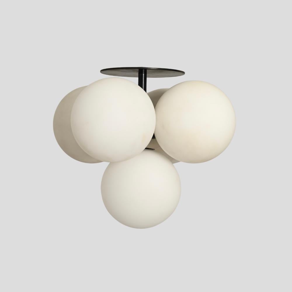 A flush mount ceiling light with five white glass globe fixtures and a dark brass or bronze pendant.