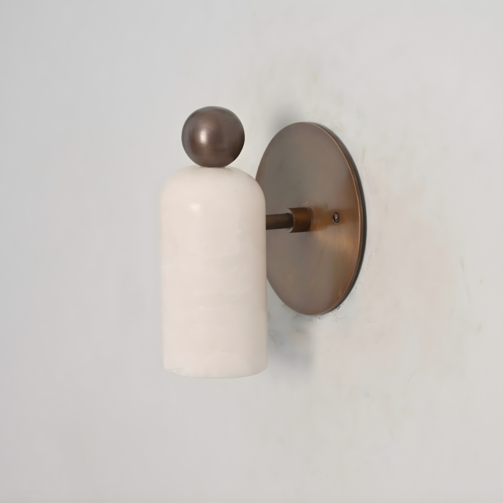 minimalist brass ball alabaster wall lamp on a gray wall