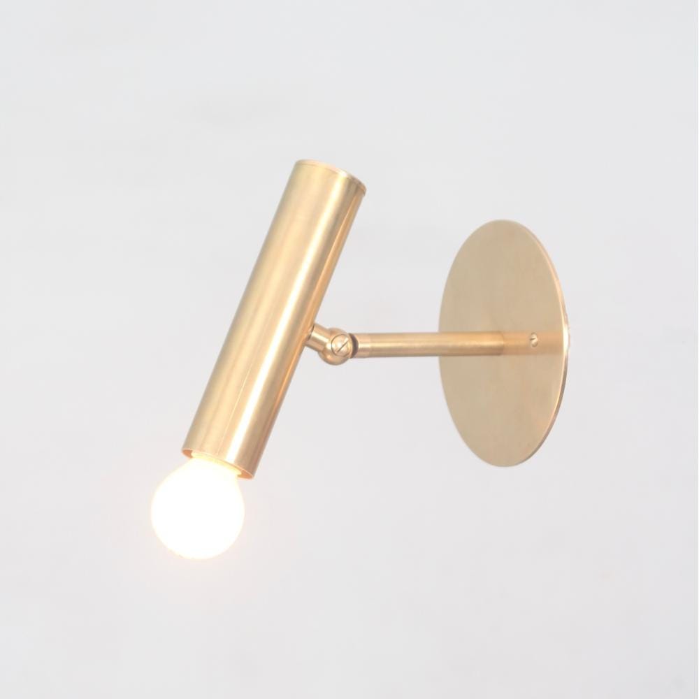 Vintage adjustable brass cylinder wall sconce on a gray background