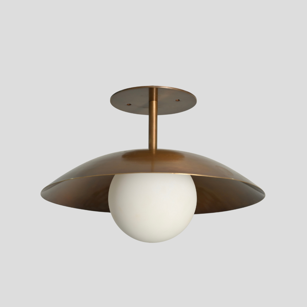 Brass flush mount with a frosted glass globe in a mid century design