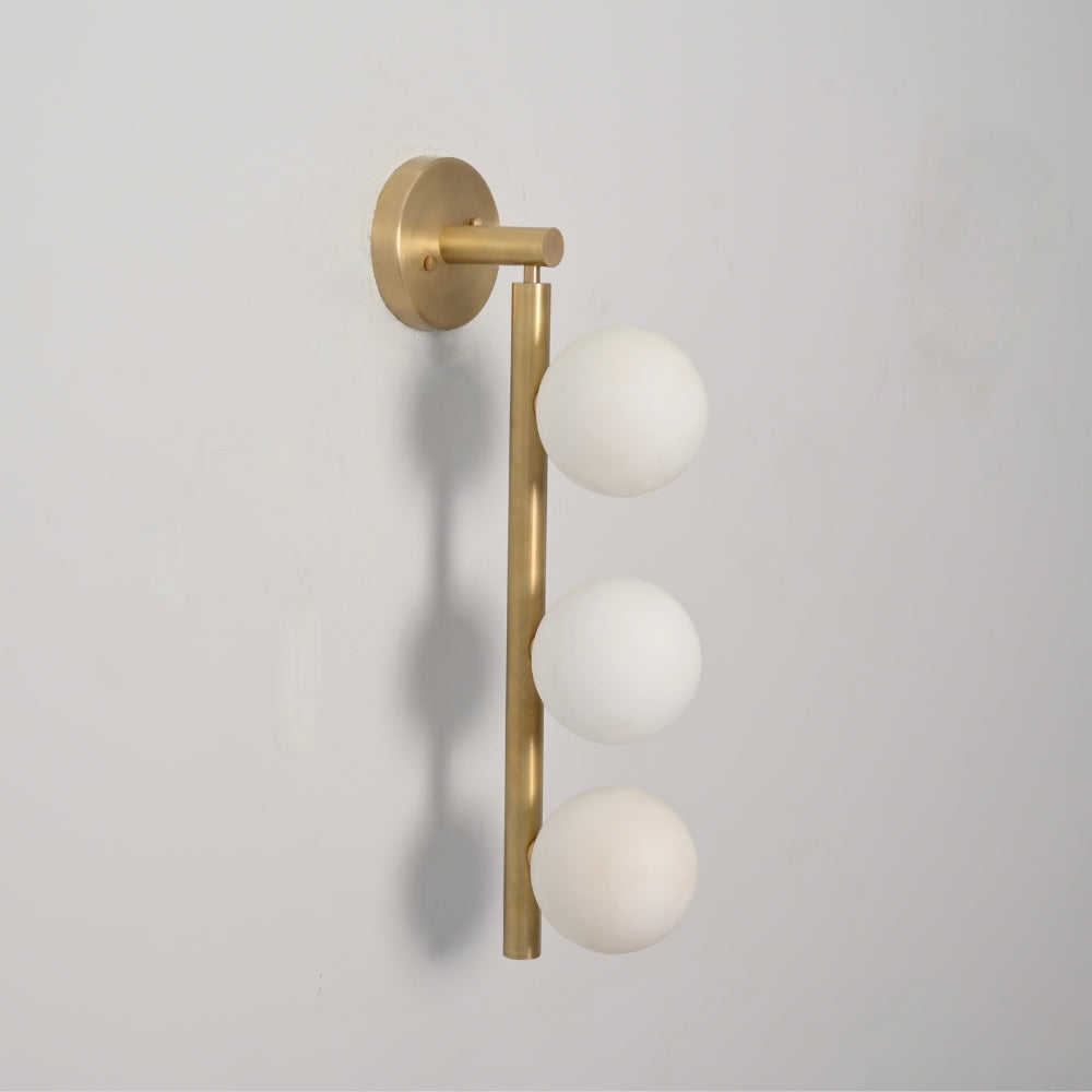 Brass wall sconce vanity light with three opal glass globe on a pure raw brass rod