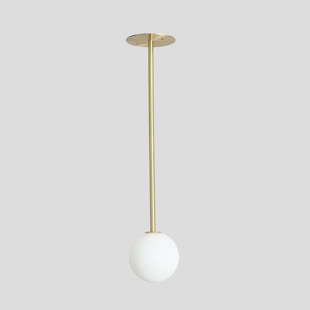 Modern brass globe with a vertical rod on a gray background designed in a mid century design