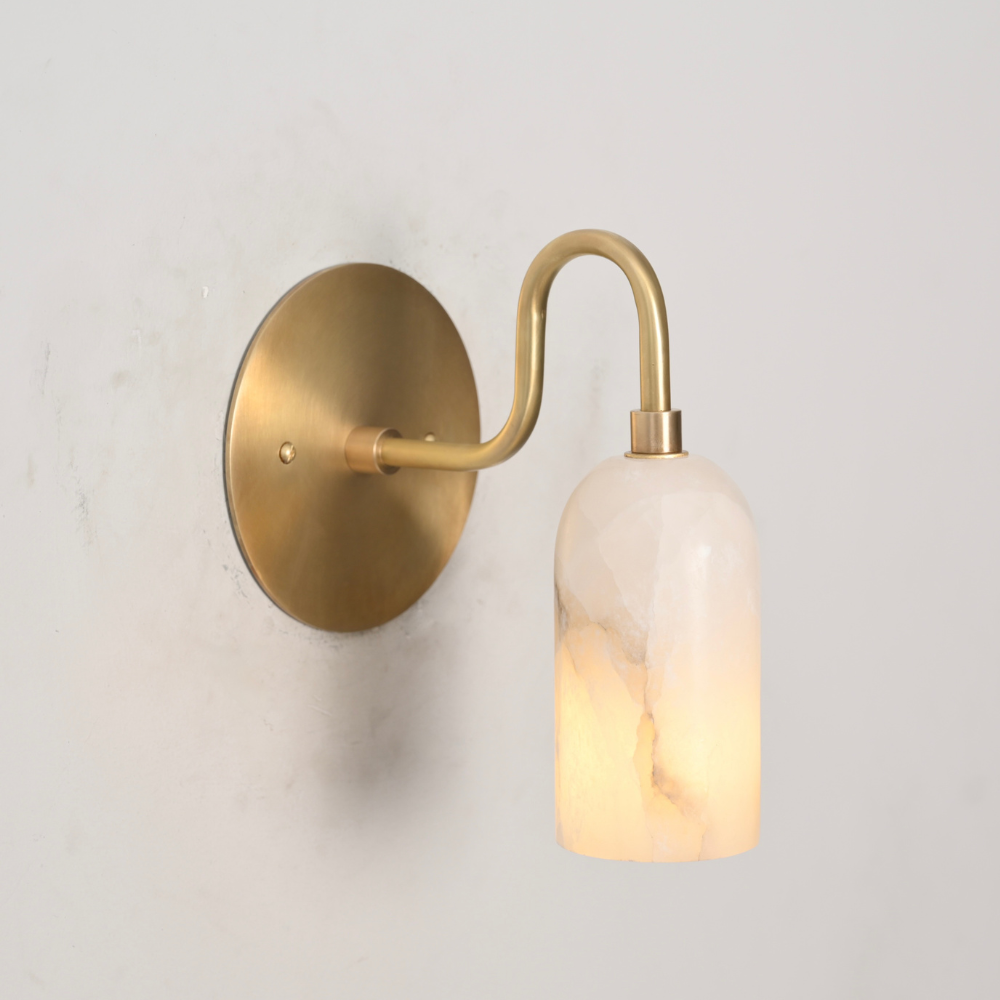 Single alabaster wall sconce with curved brass arm and round backplate