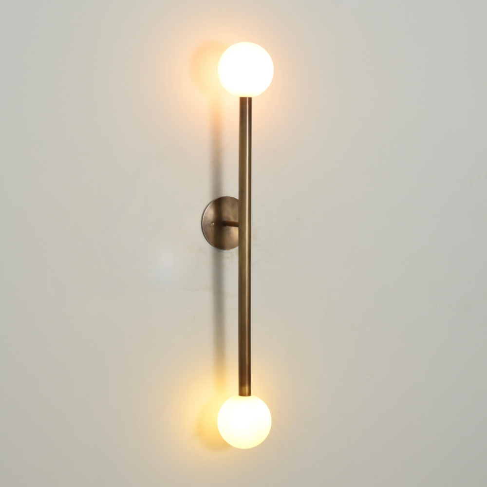 Modern wall lamp designed with 2 brass globe on a gray background and a warm light