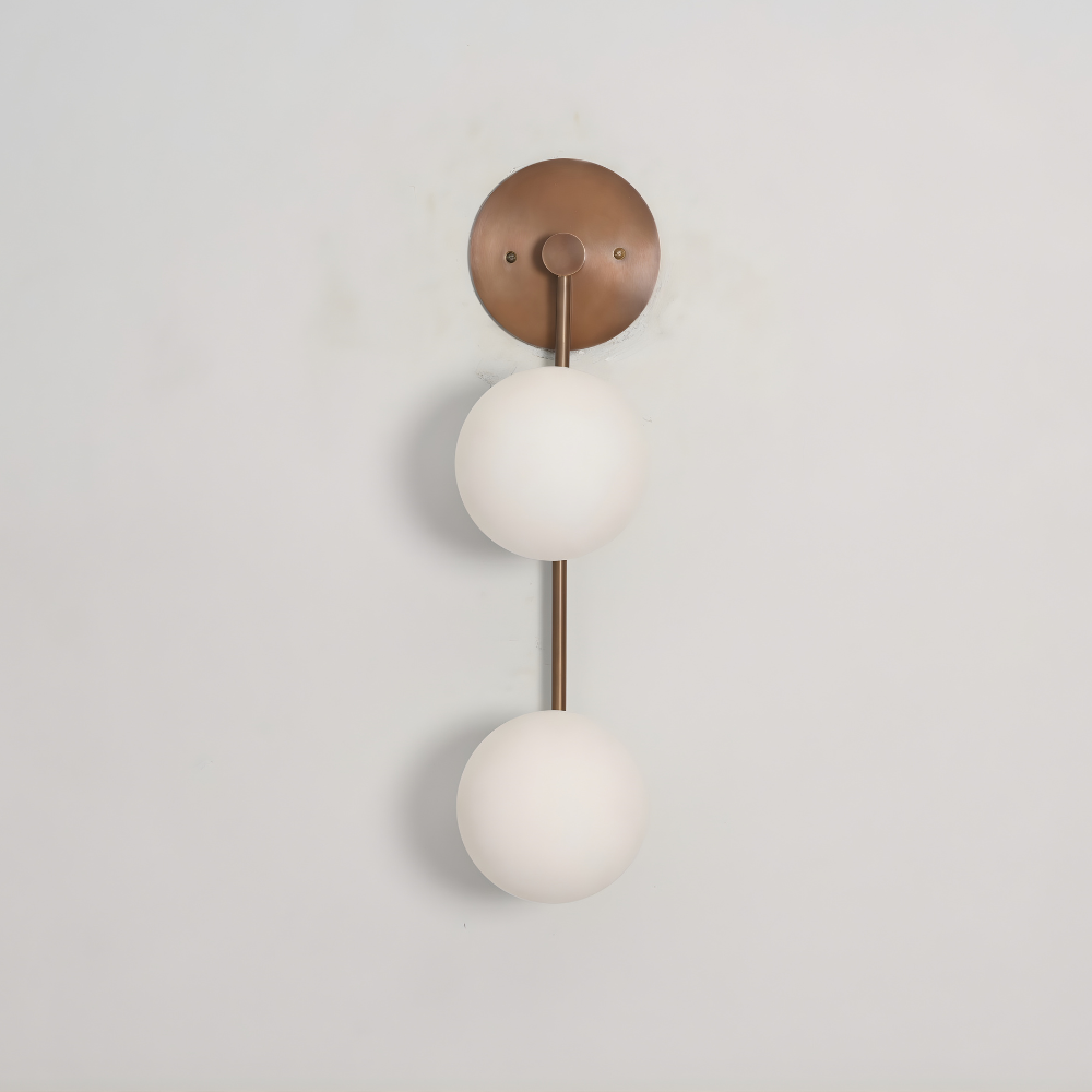 Vintage brass wall sconce handcrafted with 2 glass globe on a antique brass vertical rod on a gray wall