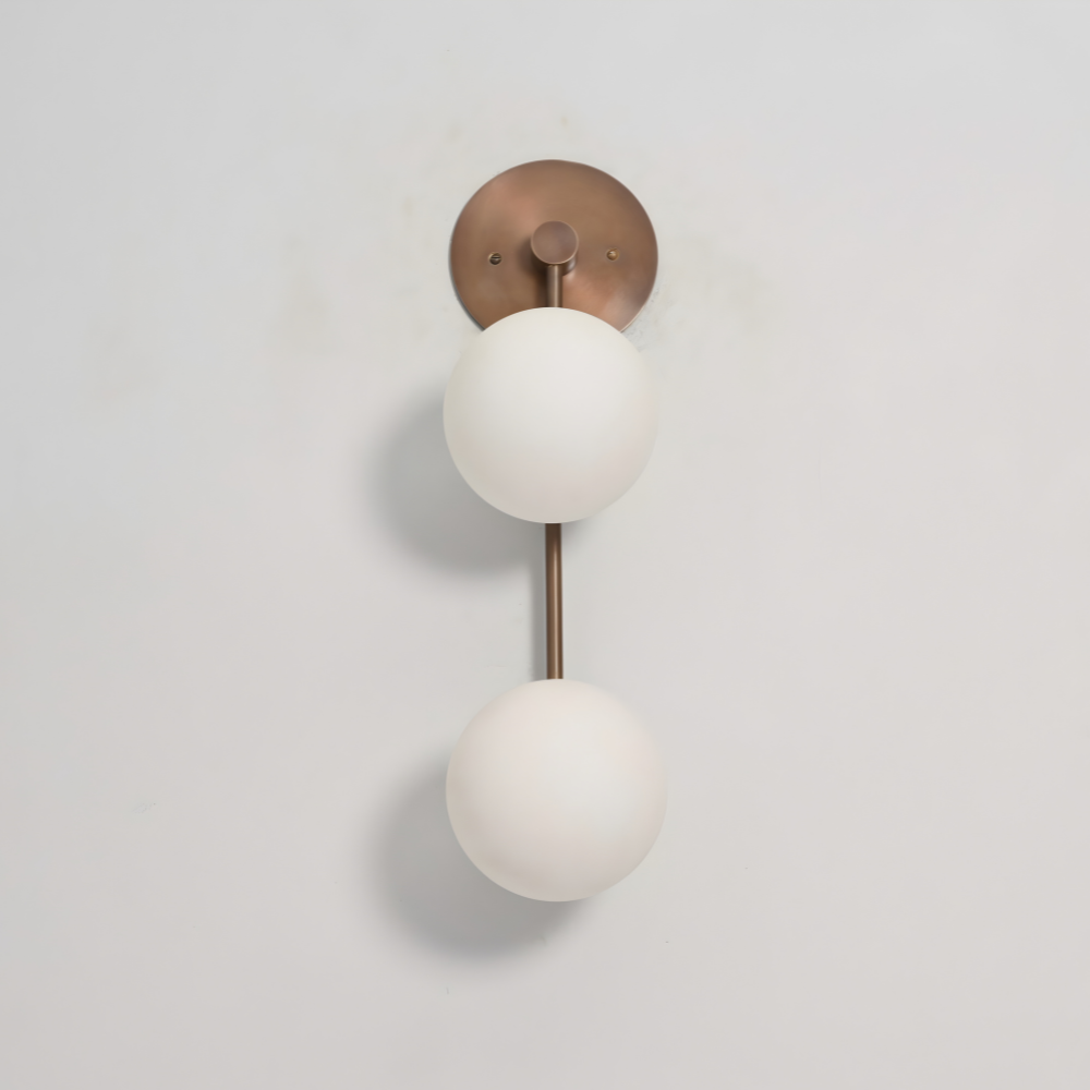 Modern frosted glass globe wall sconce with a vertical rod on a gray wall by Lightcove