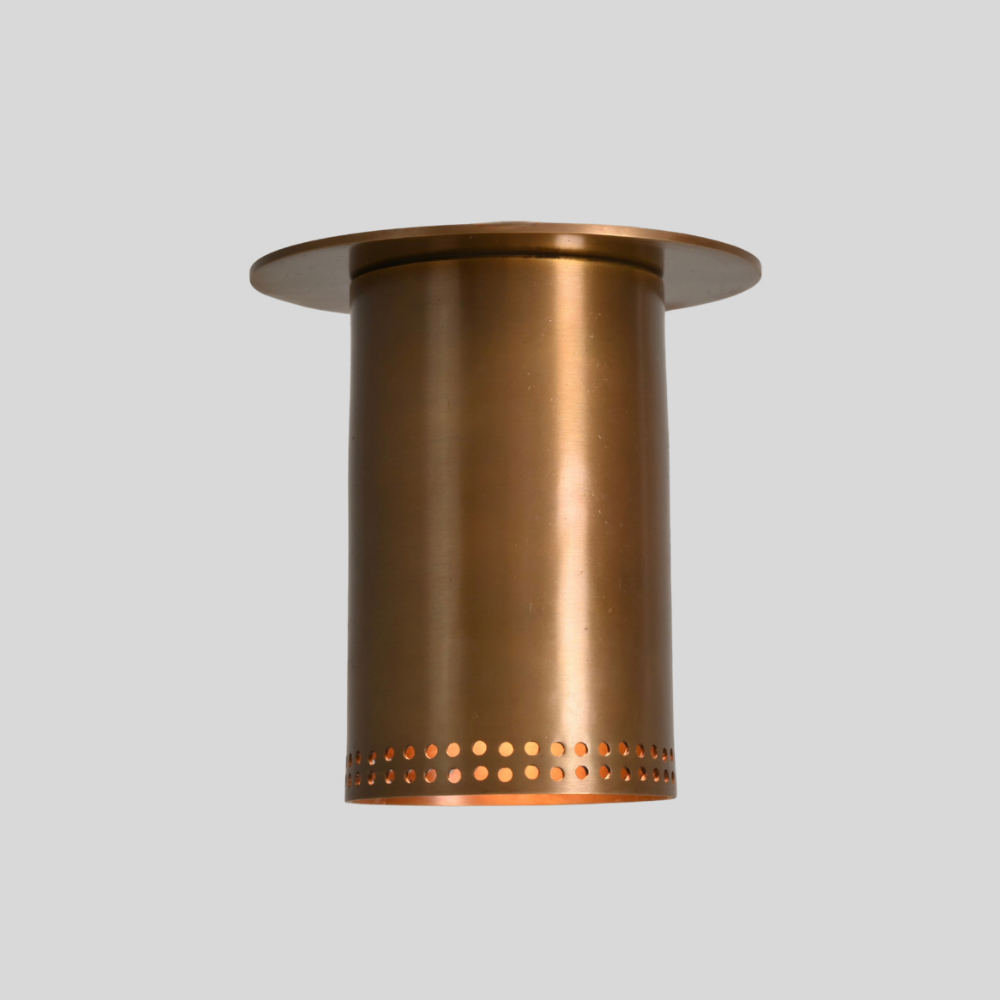 Brass flush mount spotlight with perforated rim, three-quarter view