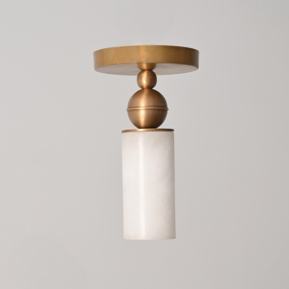 Modern ceiling fixture featuring alabaster cylinder shade and brass mount
