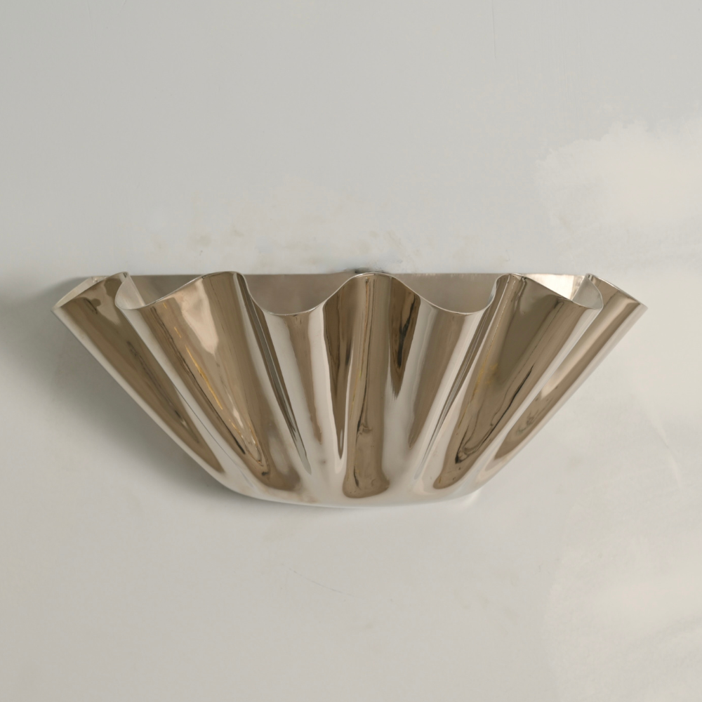 A modern flower wall sconce with a petal cut shade in a pure polished brass finish, designed by LightCove