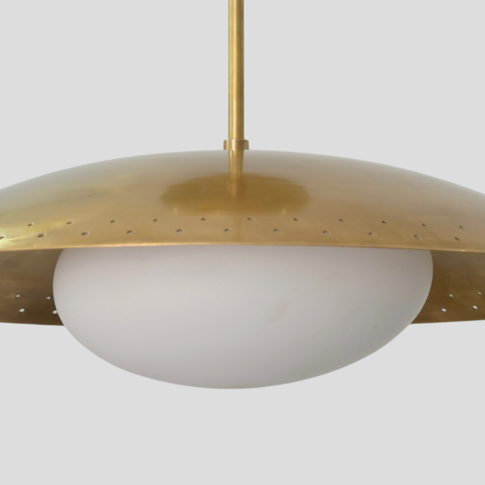Close-up detail of Perforated Brass Dome Ceiling Light - Glass Globe Pendant showing perforated dome shade in raw brass finish, brass cylindrical stem and white glass globe.