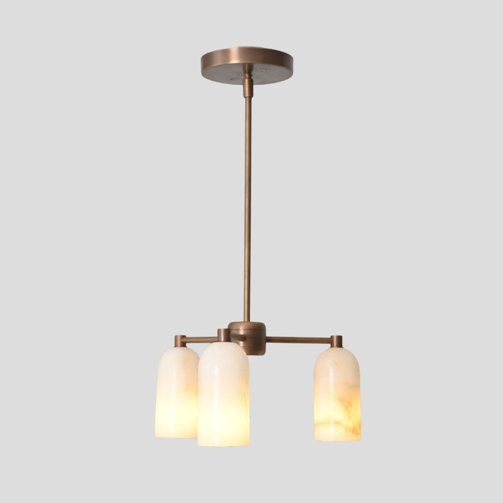 Modern pendant light with three brass marble shades on a gray background
