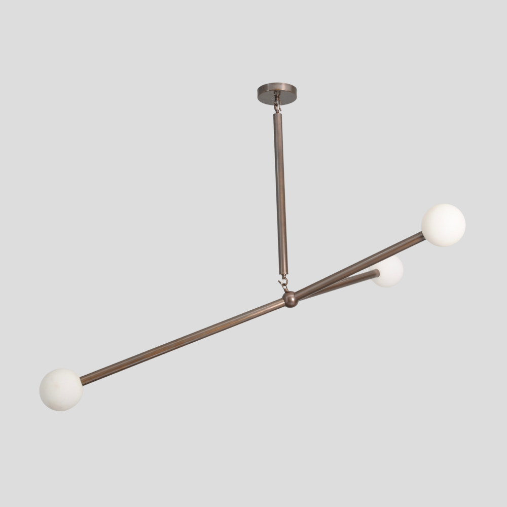 Modern ceiling light with three balanced brass globe chandelier on a gray background