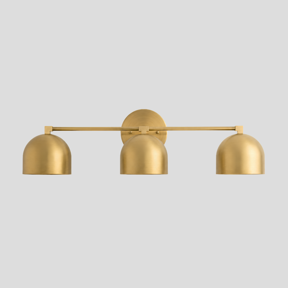 Triple Brass Dome Sconce - Mid Century Linear Arm Vanity Light with three hemispherical shades, horizontal rod, circular backplate mount, and contemporary bathroom lighting design.