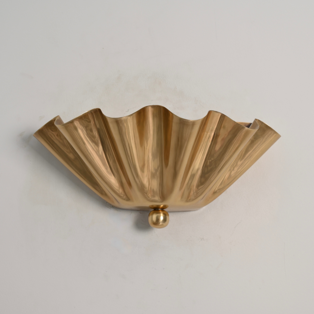 mid century half flower wall sconce with a minimalist finial shade on a gray wall