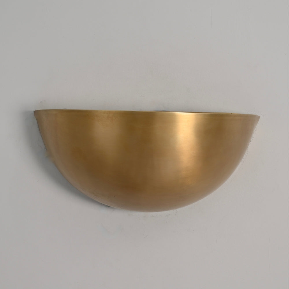 Mid century brass half moon shade wall lamp on a gray wall