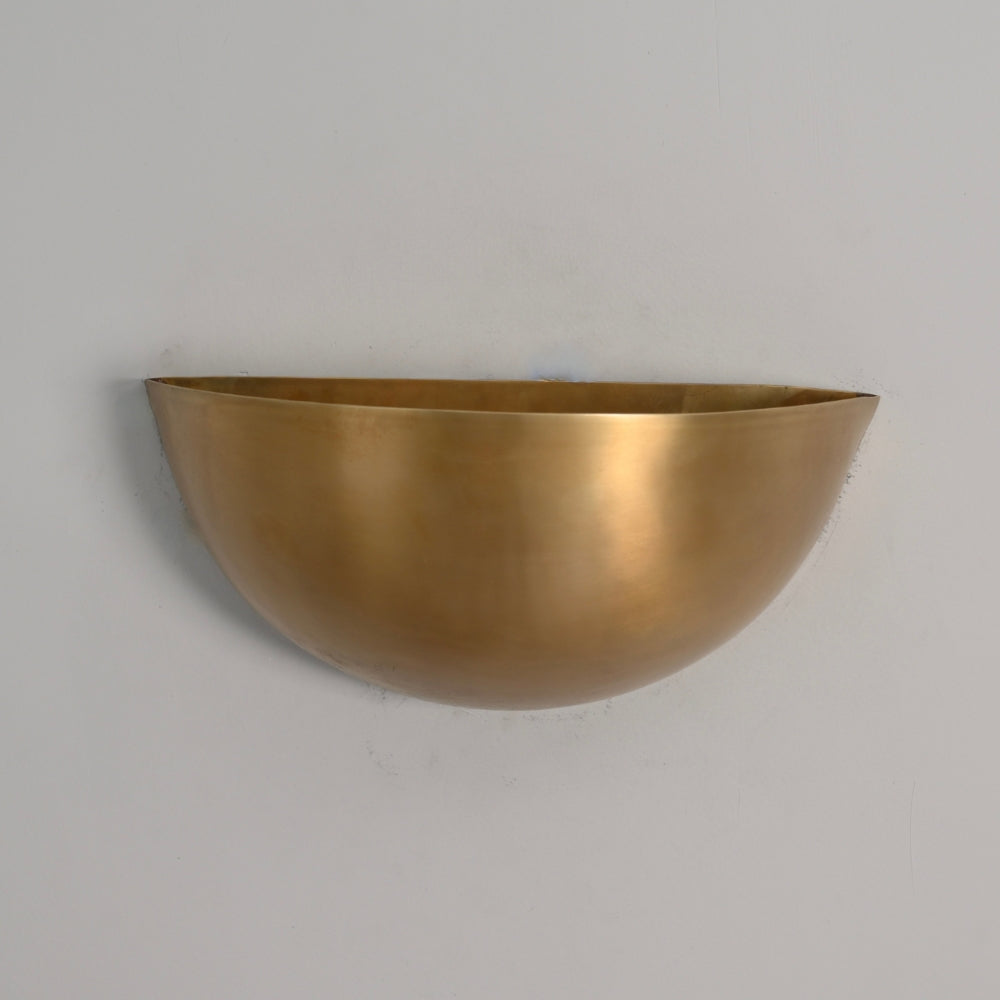 Brass wall-mounted planter on a gray background