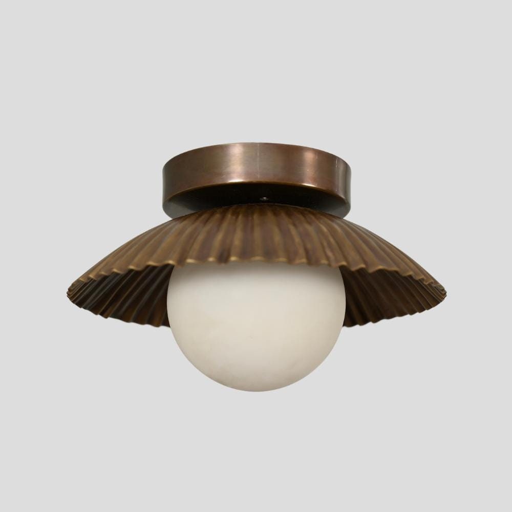 A bronze-colored flush mount ceiling light with a glass globe pendant, featuring a mid-century modern design.
