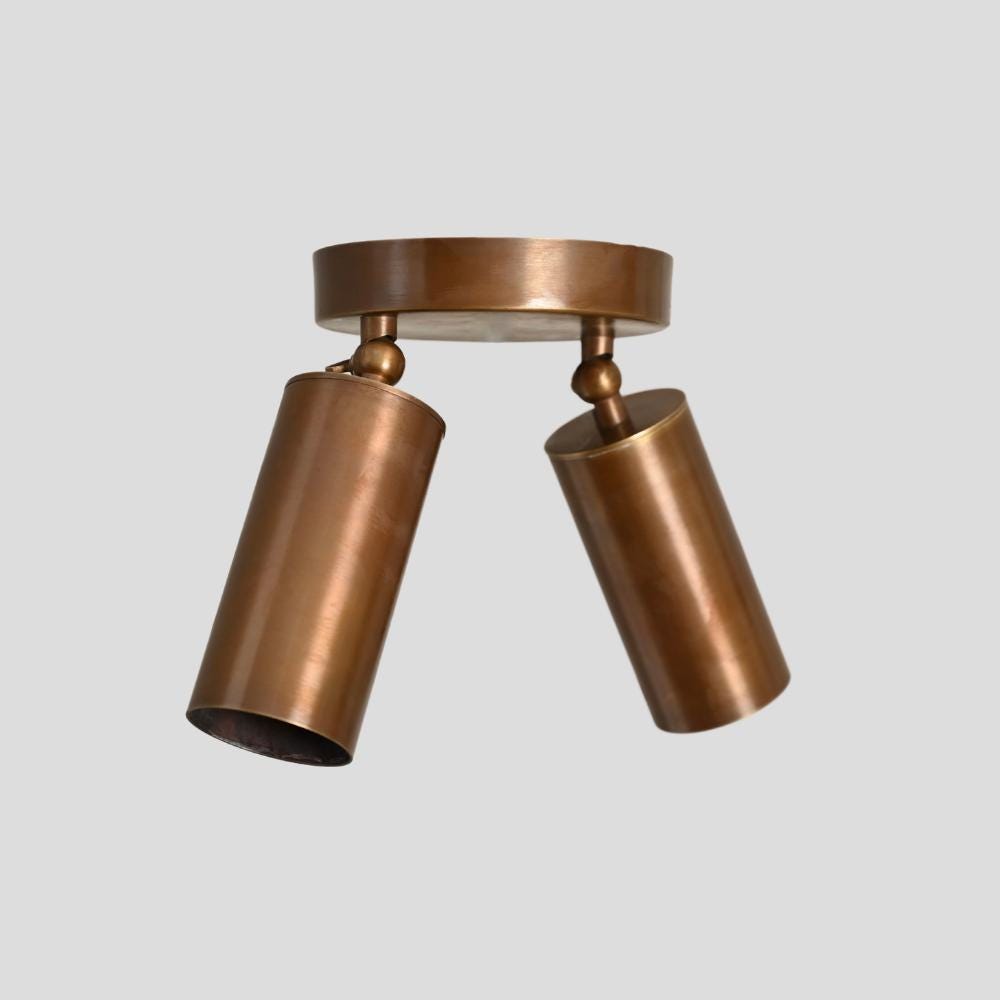 A brass ceiling double spot light with adjustable angle fixtures, in a bronze or brown color, with a modern design.