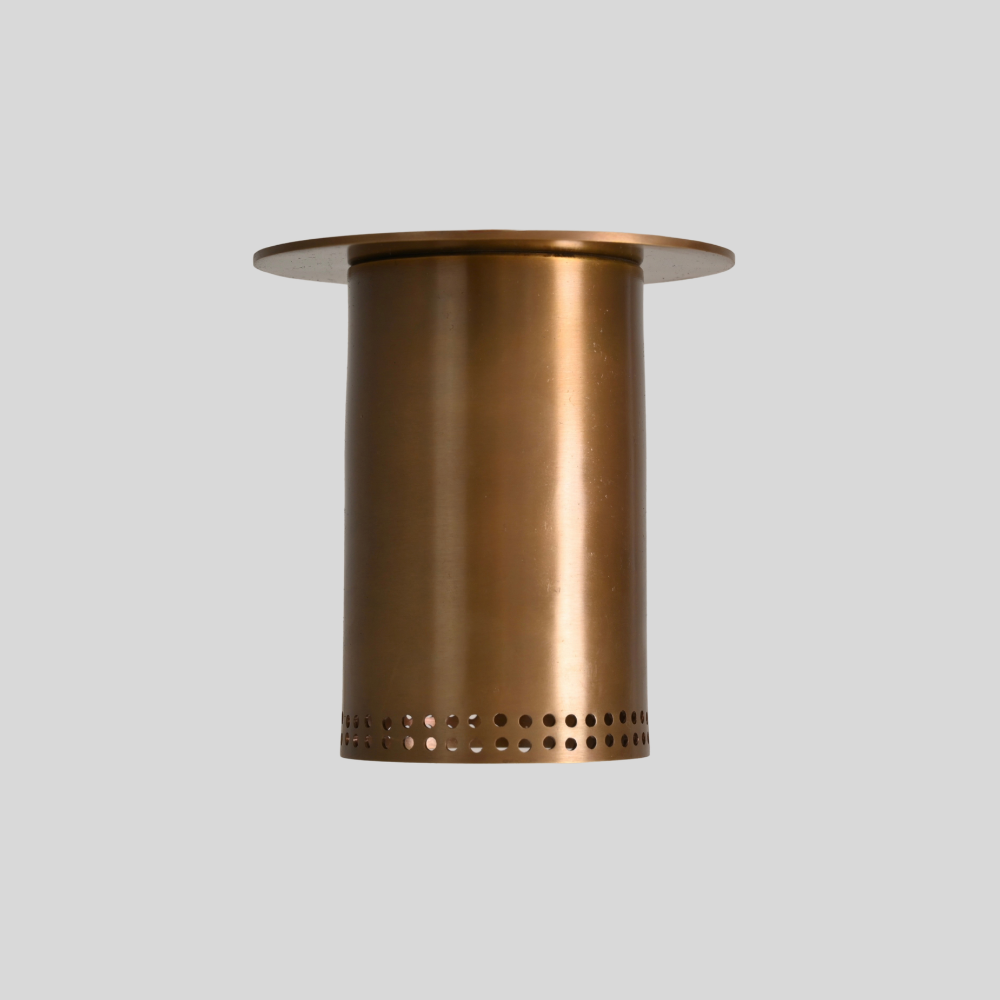 Brass flush mount spotlight with perforated rim, close-up of the brass fittings