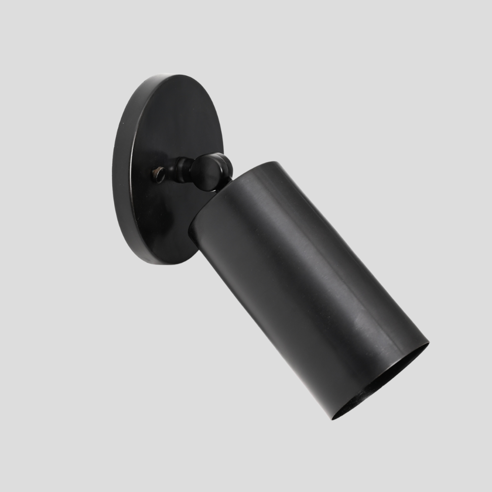 Black cylinder adjustable wall-mounted lamp on a light gray background