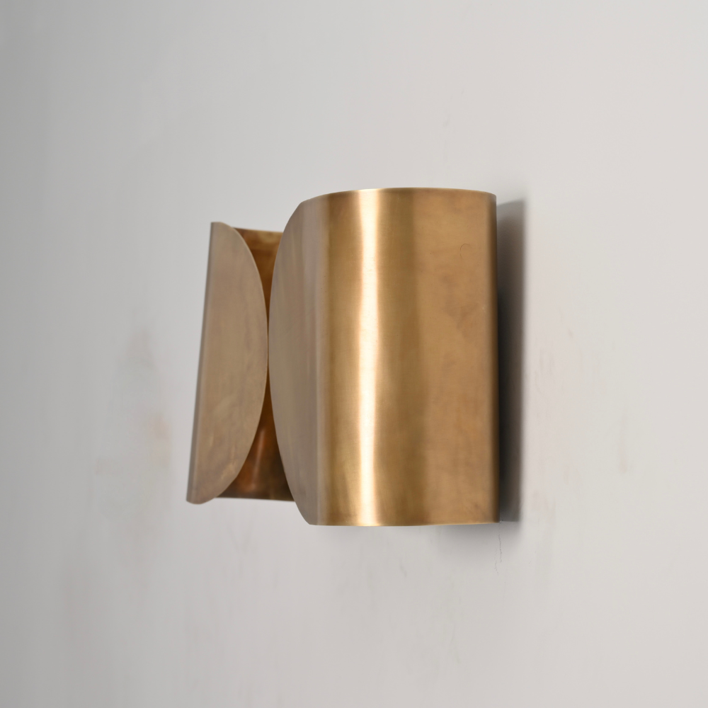 Close up on the brass curved shade of modern wall sconce 
