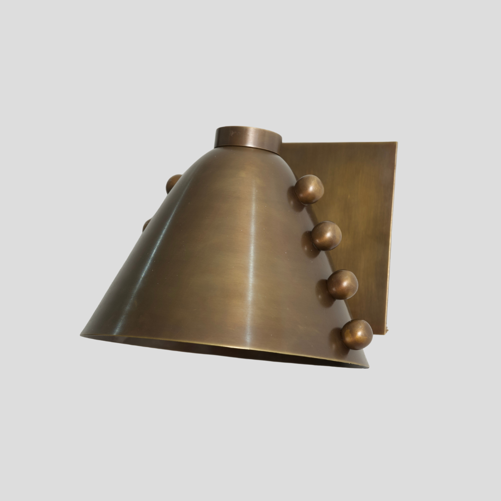Bronze wall sconce with decorative elements on a light gray background