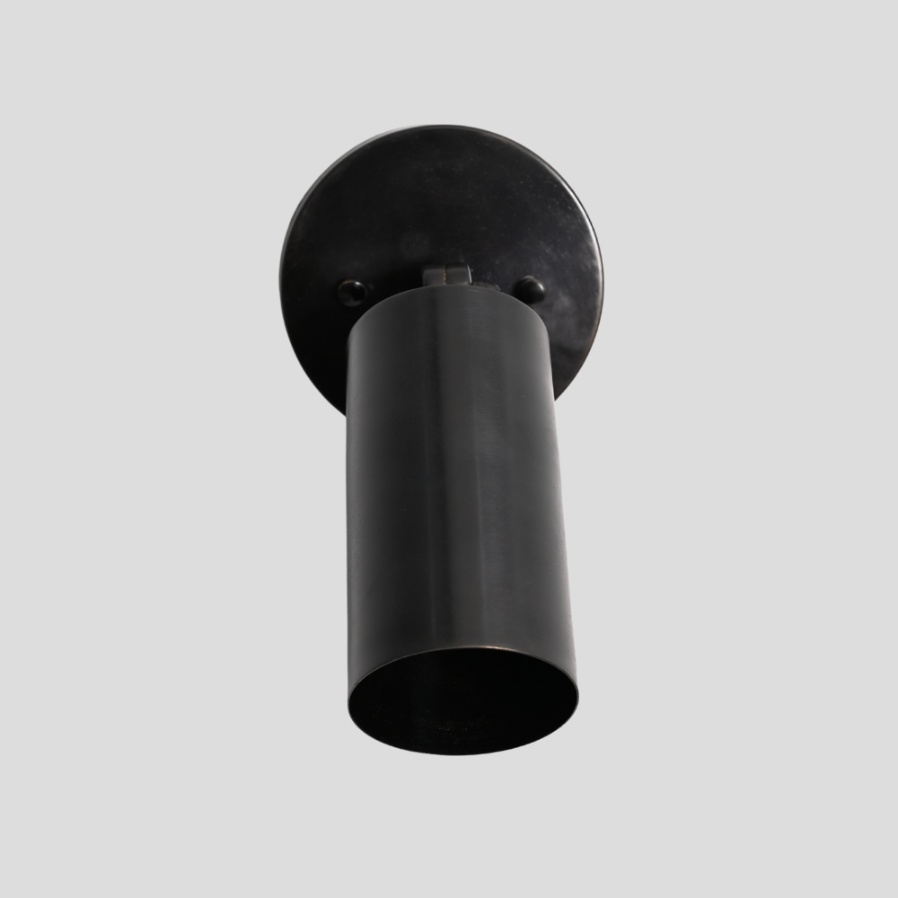 Brass antique Black cylindrical wall light fixture on a gray background