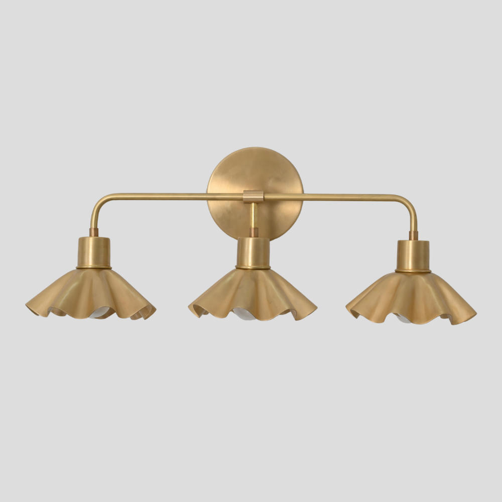 3 brass vanity light designed in a minimalist design on agray background
