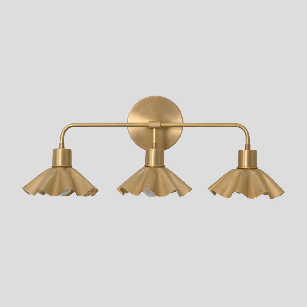 Mid century modern triple vanity light with a petal shade on a gray background