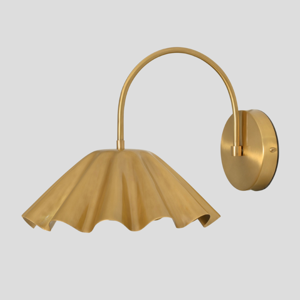 Gold wall lamp with a unique shade design on a light gray background