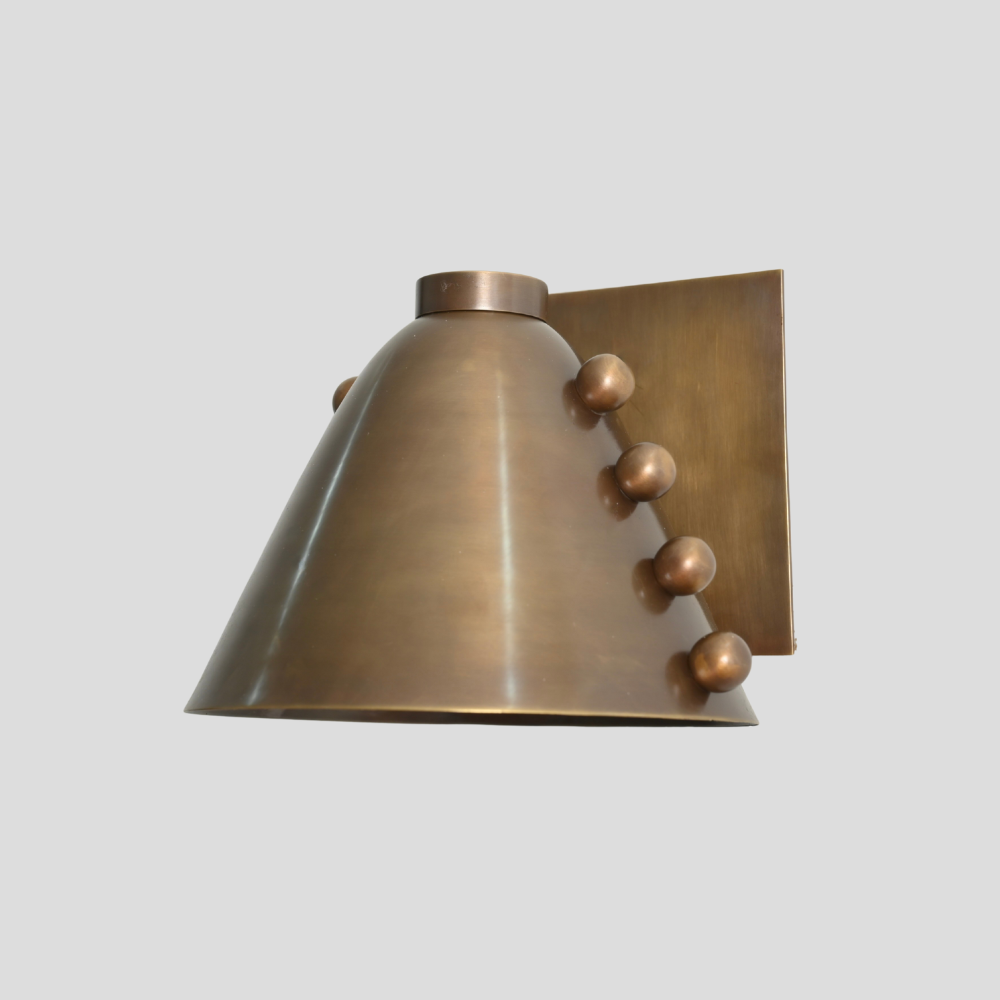 Bronze wall sconce with decorative elements on a light gray background