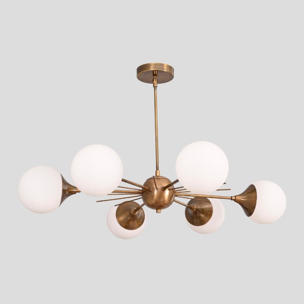 A mid century ceiling light with § brass glass globe on a gray background