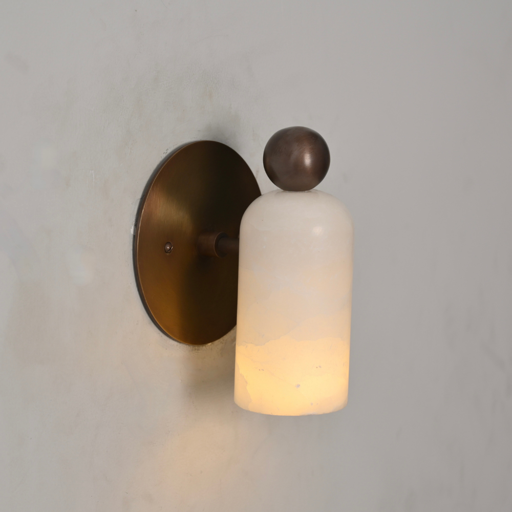 Vintage brass stub arm with a decorative ball and marble shade in a warm lighting 