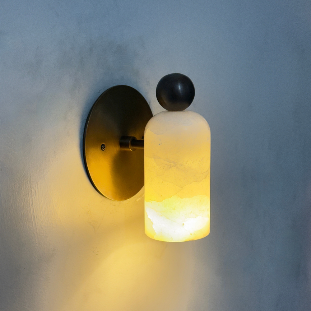 Vintage brass alabaster wall sconce with a decorative ball on a warm lighting 