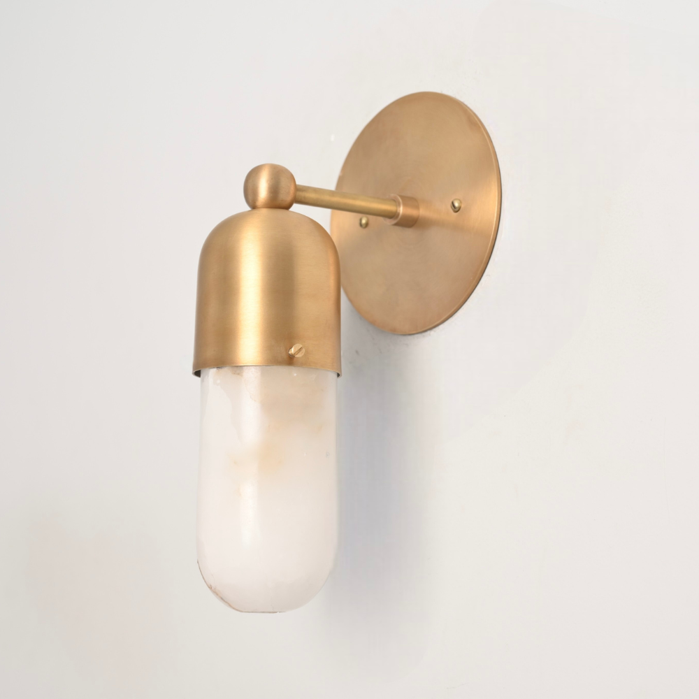 Modern brass alabaster wall sconce softly illuminated