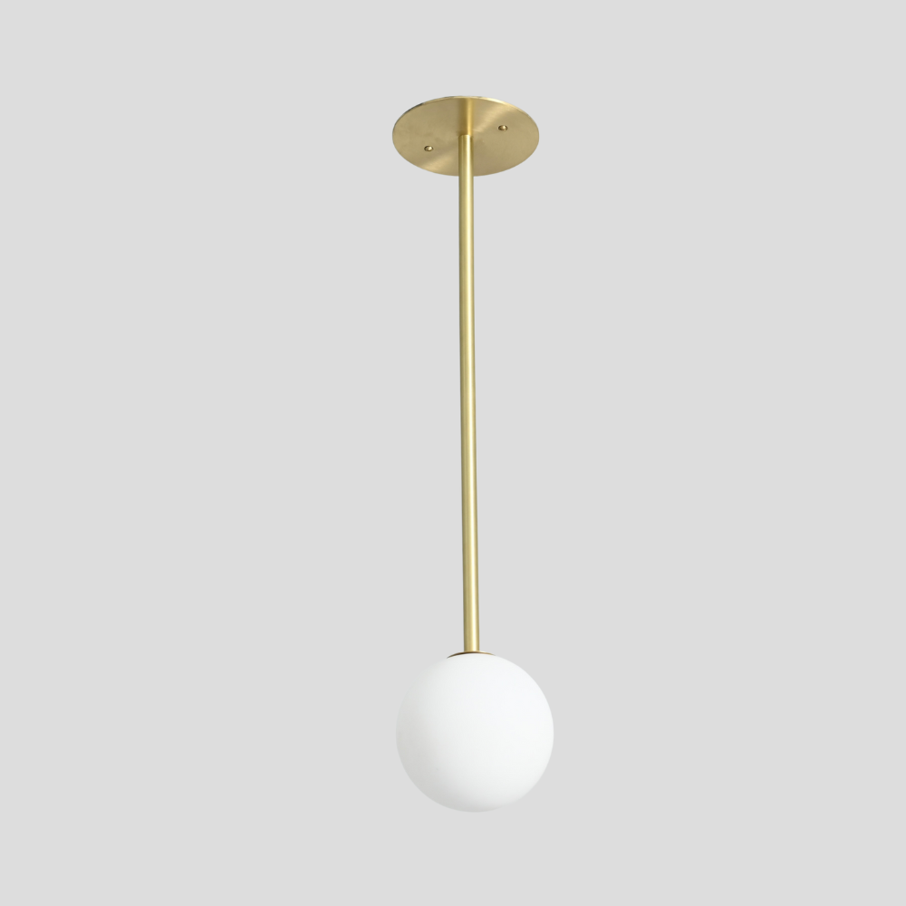 Vertical single globe pendant handcrafted in a pure raw brass finish by LightCove 