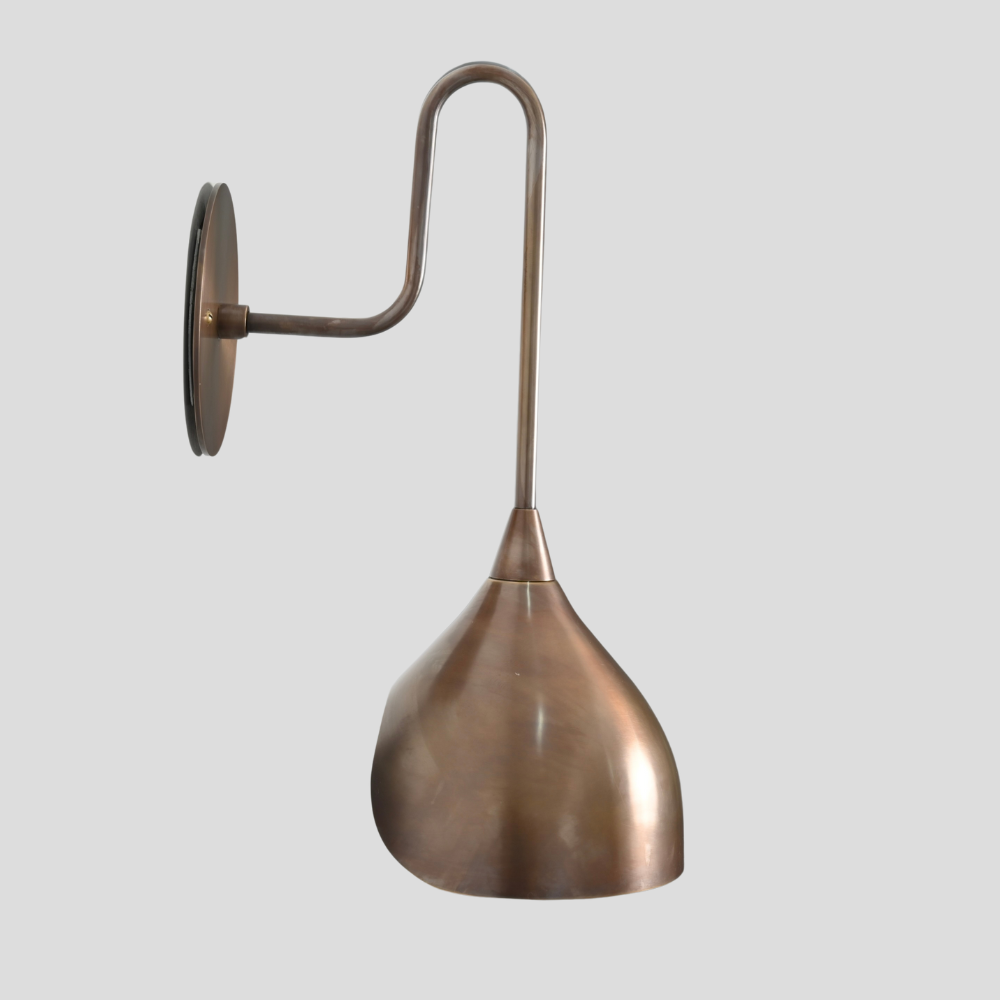 Bronze wall-mounted lamp with a curved arm on a light gray background