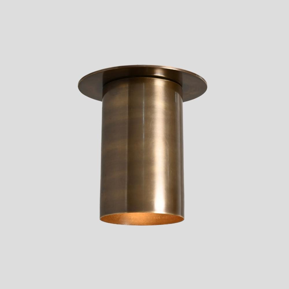 A brass ceiling spot light with a cylindrical shape and a flush mount design, showing a warm brass finish.