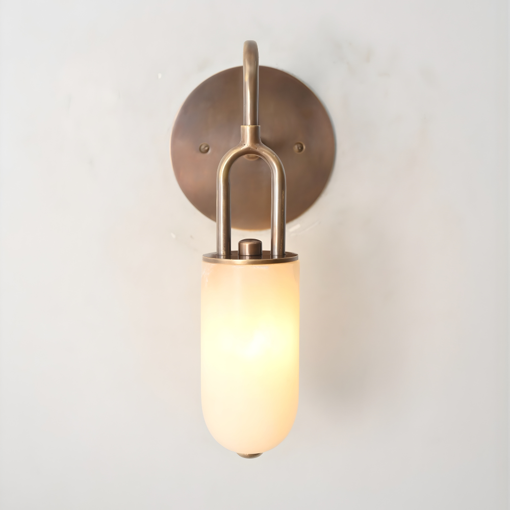 Wall-mounted light fixture with a cylindrical alabaster shade on a plain background