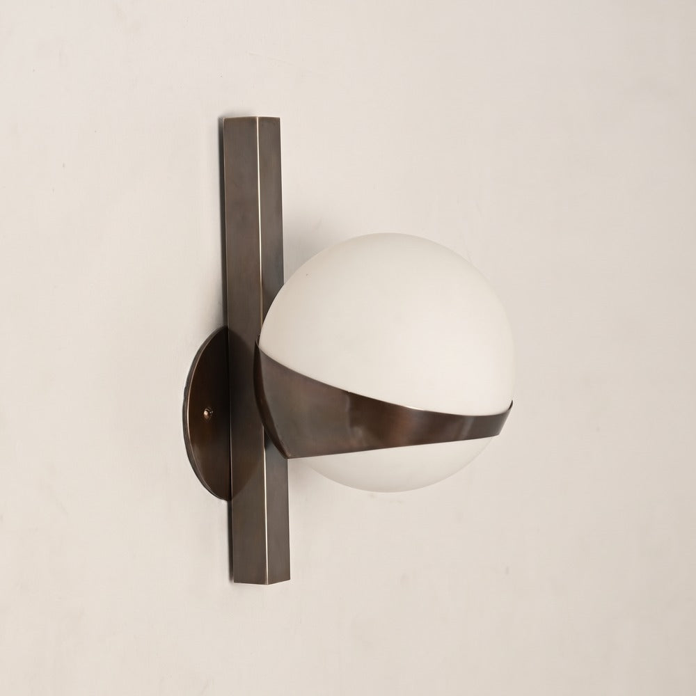 Antique brass globe sconce with a square vertical bar and round backplate, side view
