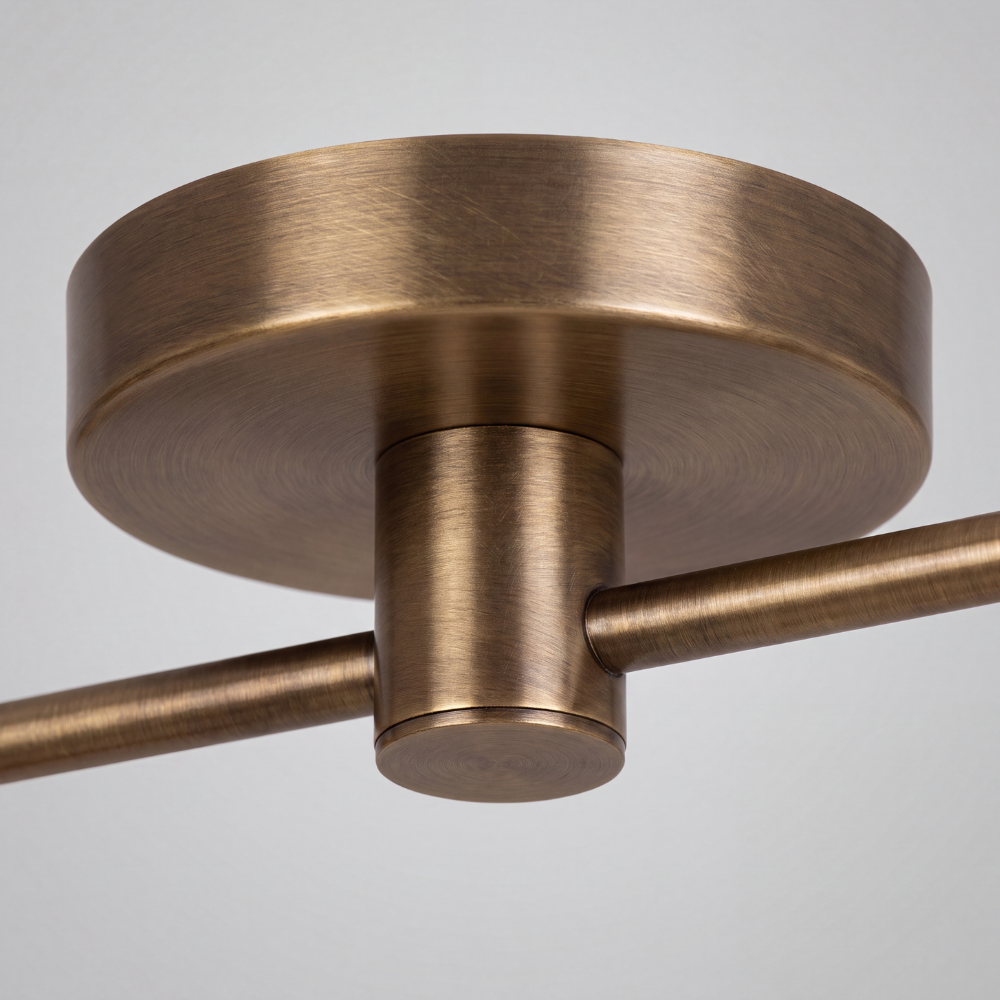 Close-up detail view of Double Brass Cone Shade Flush Mount - Adjustable Ceiling Light showing circular canopy backplate and horizontal brass arm in Antique Brass finish.